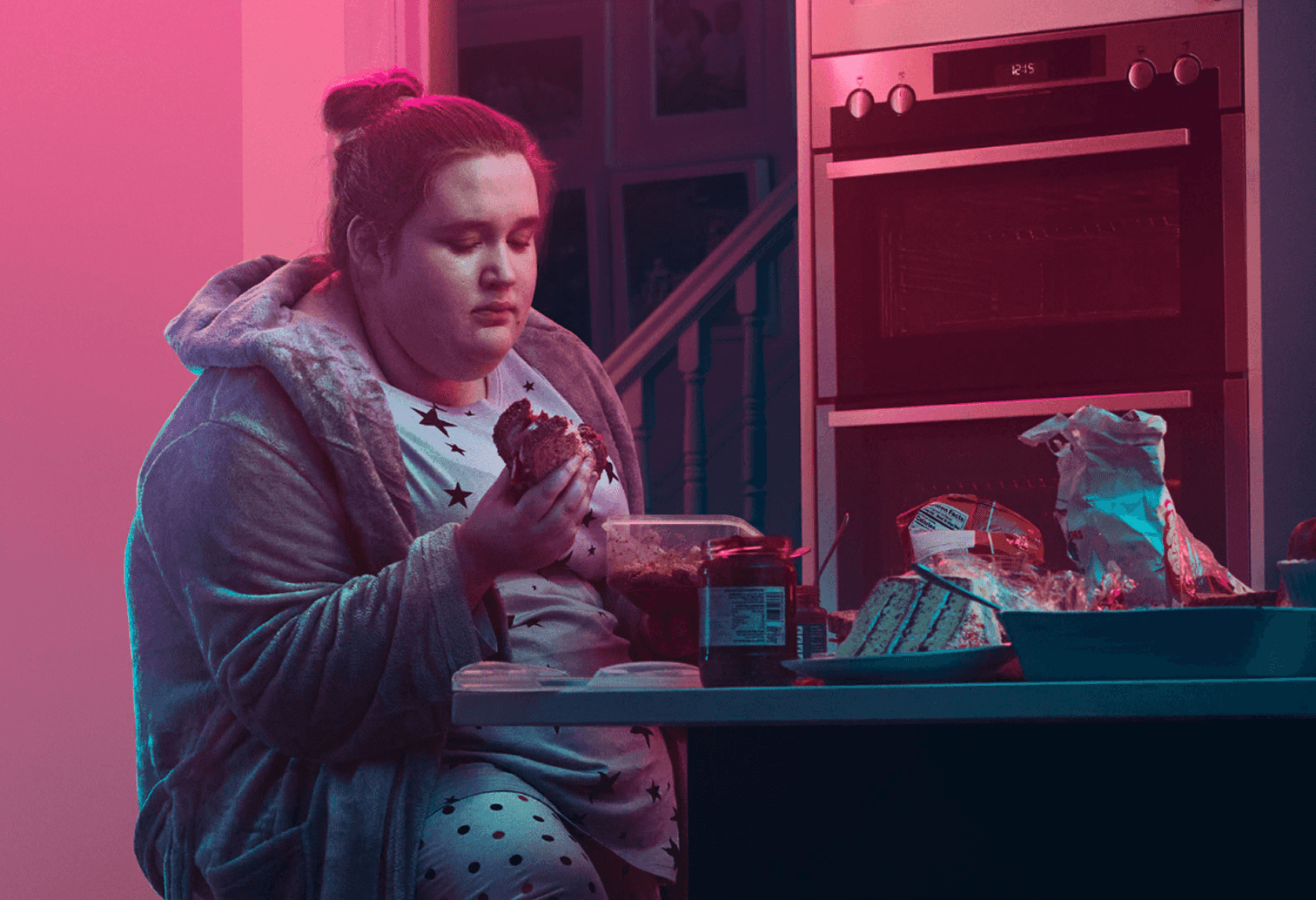 Girl sitting at kitchen counter and eating. Actor portrayal.