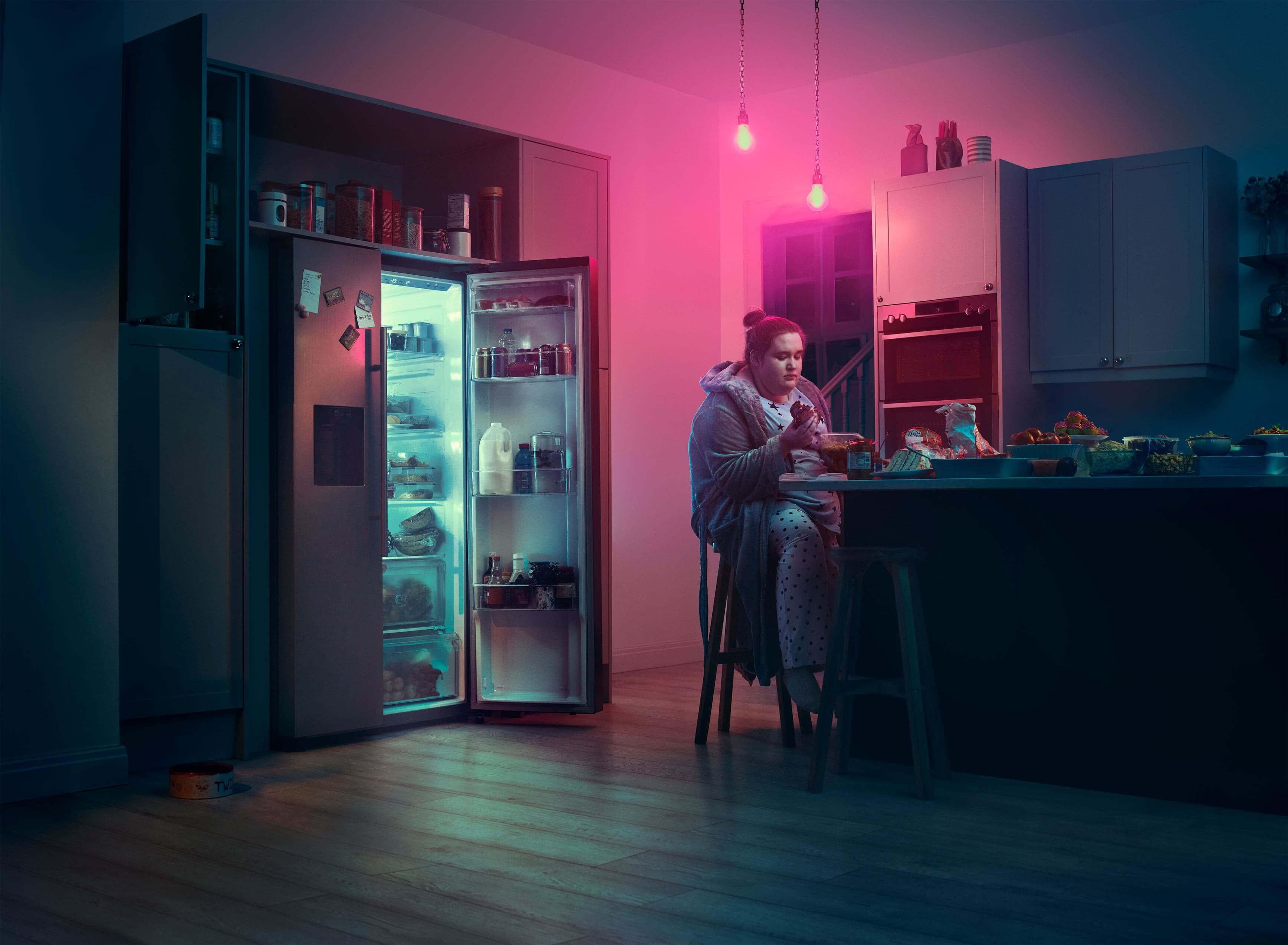 Girl sitting at kitchen counter and eating. Actor portrayal.